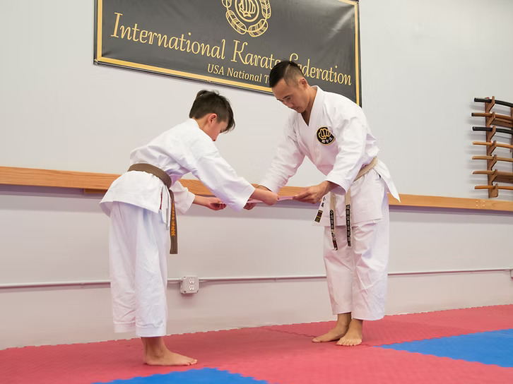 sensei gives student certificate for new belt rank